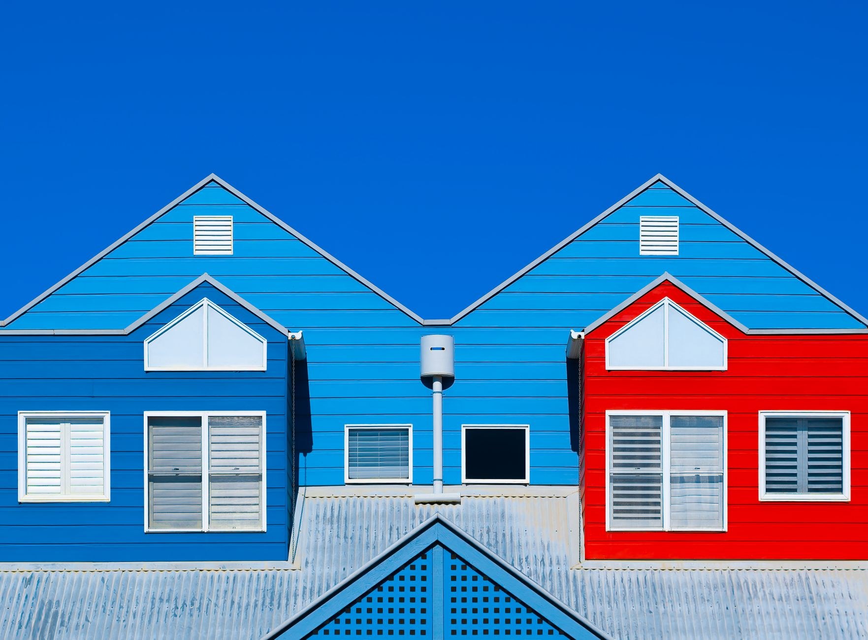 Freshly painted weatherboard house exteriors against a blue sky